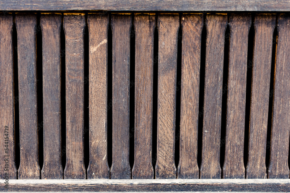 Old wood fence with detailed surface of a rustic home and distanced planks