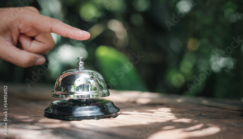 Hospitality hotel. Customer hand ringing service bell at coffee cafe shop for calling the staff to receive the menu, Woman finger touching to ring bell