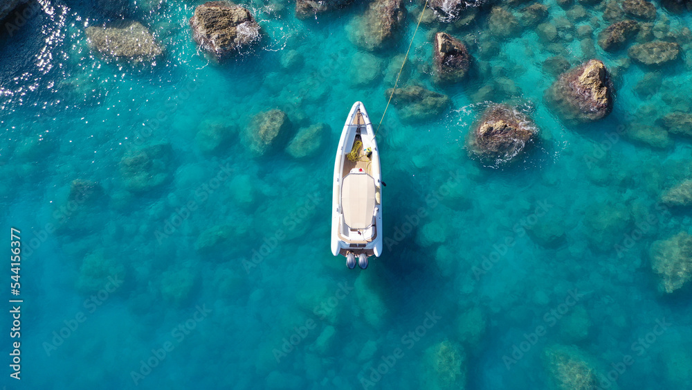 Aerial drone top down photo of white inflatable rib speed boat anchored in tropical exotic rocky bay with emerald sea - obrazy, fototapety, plakaty 