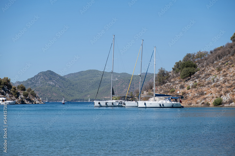 Beautiful bay with sailing boats, yachts in turquoise sea and mountains, luxury holidays or sailing regata sports.