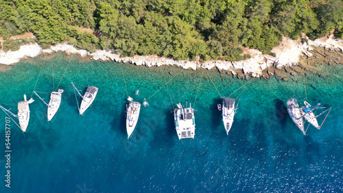 Aerial drone top down photo of sail boats and yachts anchored in traditional fishing village of Fiskardo, Kefalonia island, Ionian, Greece