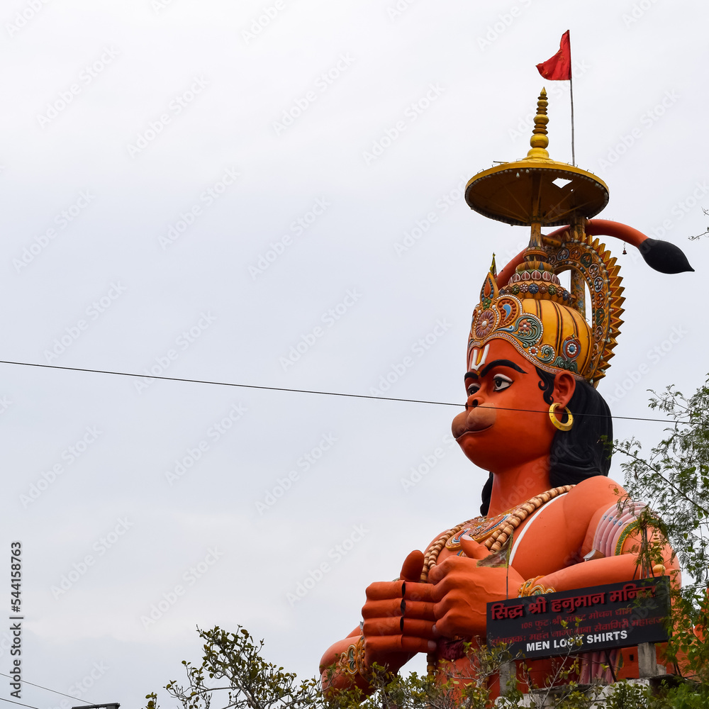 Big statue of Lord Hanuman near the delhi metro bridge situated near Karol Bagh, Delhi, India, Lord Hanuman big statue touching sky - obrazy, fototapety, plakaty 