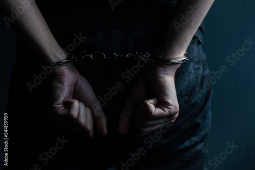 male hands in handcuffs black background