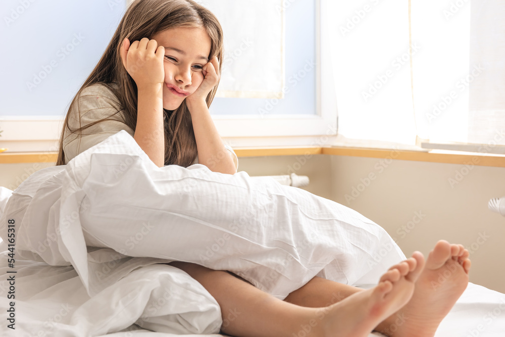 Adorable little girl in her bed early in the morning.