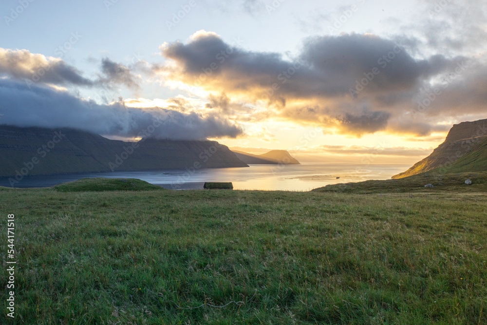 Obraz premium Sunset over the fjord. Faroe Islands rural landscape.