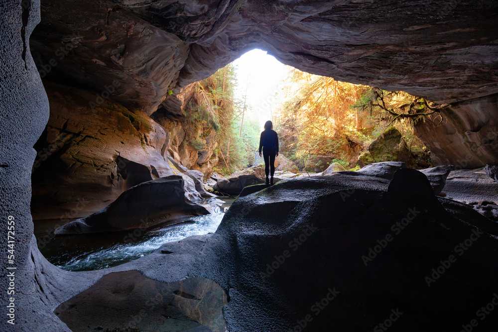 Adventurous woman standing inside a cave. Adventure Travel. Little Huson Caves Park, Vancouver Island, British Columbia, Canada.