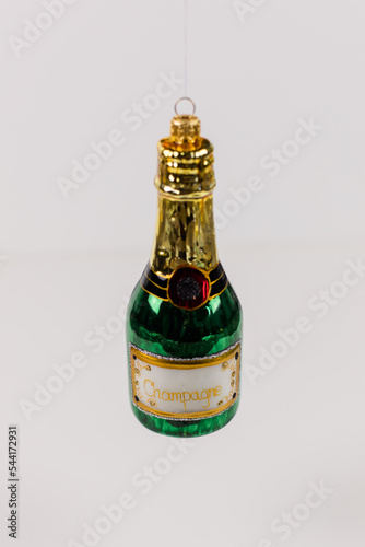 A single Christmas tree bauble in the shape of a green champagne bottle. photo