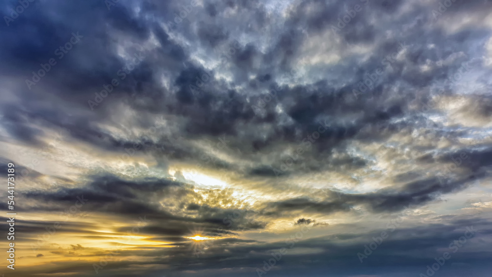 Obraz premium Evening sunset sun with dark clouds in autumn