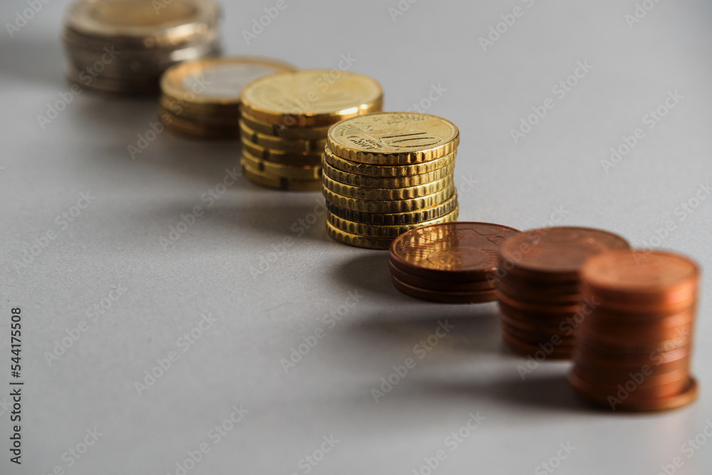 Stacks of euro coins of different sizes arranged in a row. Soft focus Stacks of euro coins of different sizes arranged in a row. Soft focus