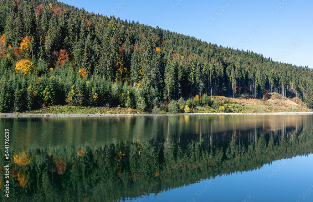 Autumn forest and lake in a mountainous area, natural background.