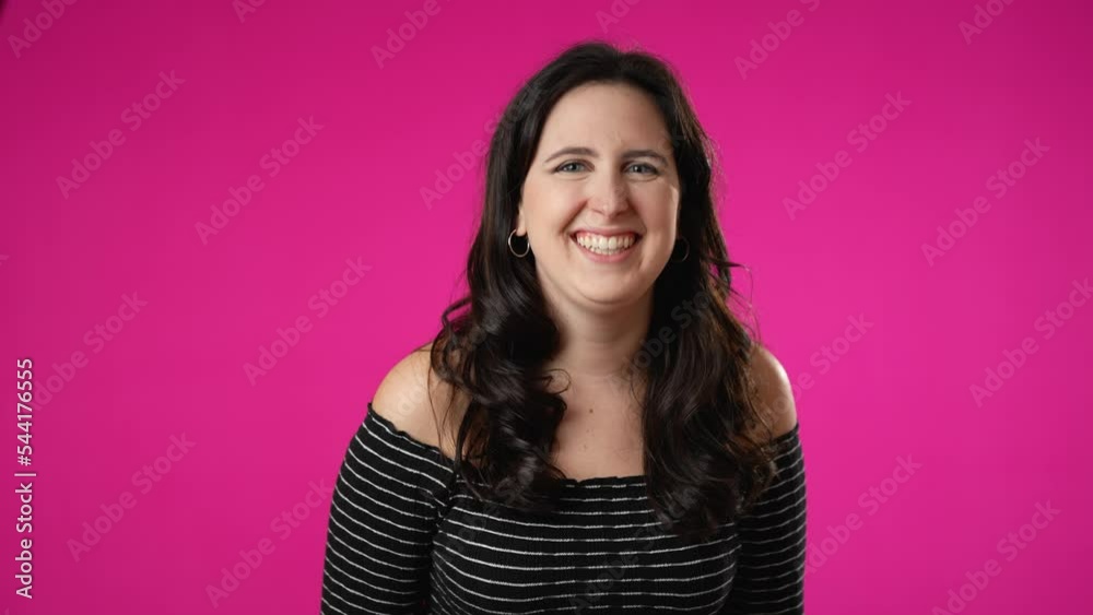 Smiling beautiful brunette young woman 20s 30s years old posing isolated on pink background studio. People sincere emotions lifestyle concept. Looking at camera with charming smile Smiling beautiful brunette young woman 20s 30s years old posing isolated on pink background studio. People sincere emotions lifestyle concept. Looking at camera with charming smile