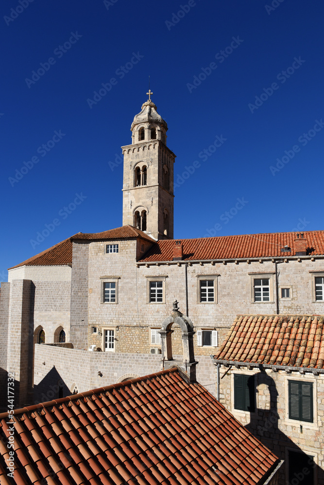 slim tower above the Dominican Monastery with classic red tiled rooftops inside the old town of Dubrovnik, Croatia

