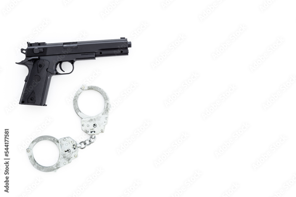 Hand gun weapon with handcuffs - illegal use of weapons concept Hand gun weapon with handcuffs - illegal use of weapons concept