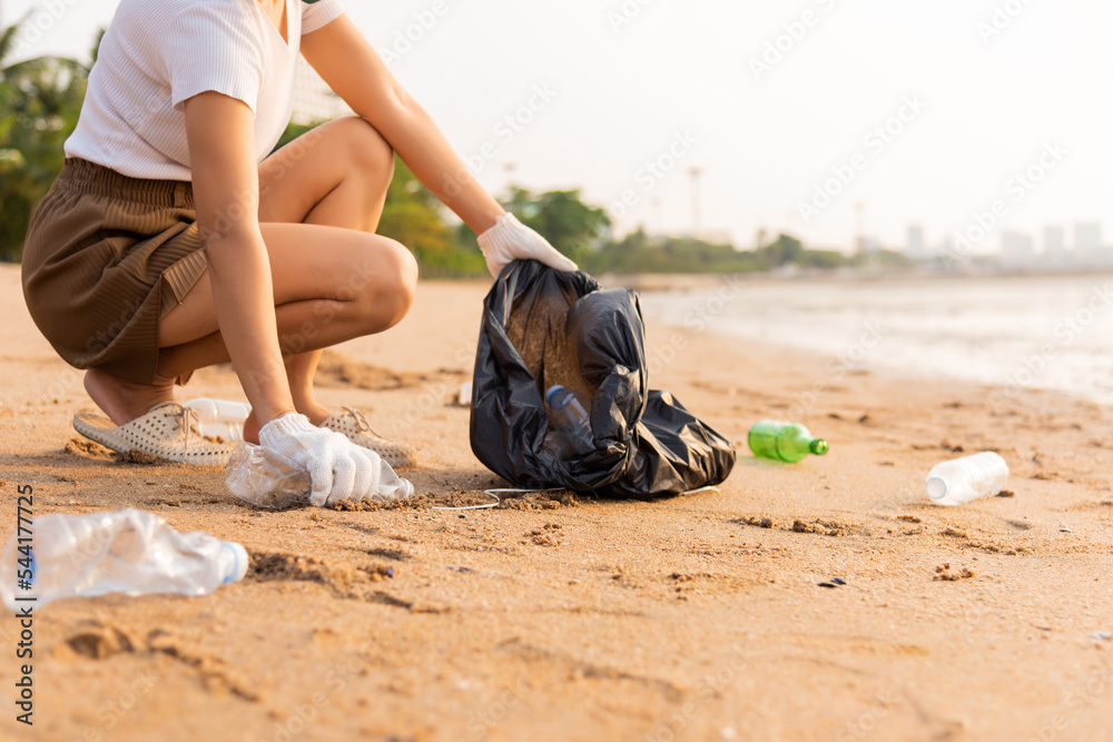 Volunteer woman picking plastic bottle into trash plastic bag black for  cleaning the beach, female clean up garbage, Ecology concept and World  Environment Day, Save earth concept Stock Photo | Adobe Stock