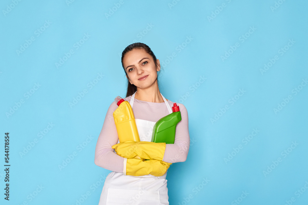 woman in gloves and cleaner apron holding bottle of detergent woman in gloves and cleaner apron holding bottle of detergent