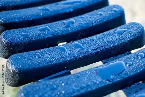 Plastic bench covered with morning dew.