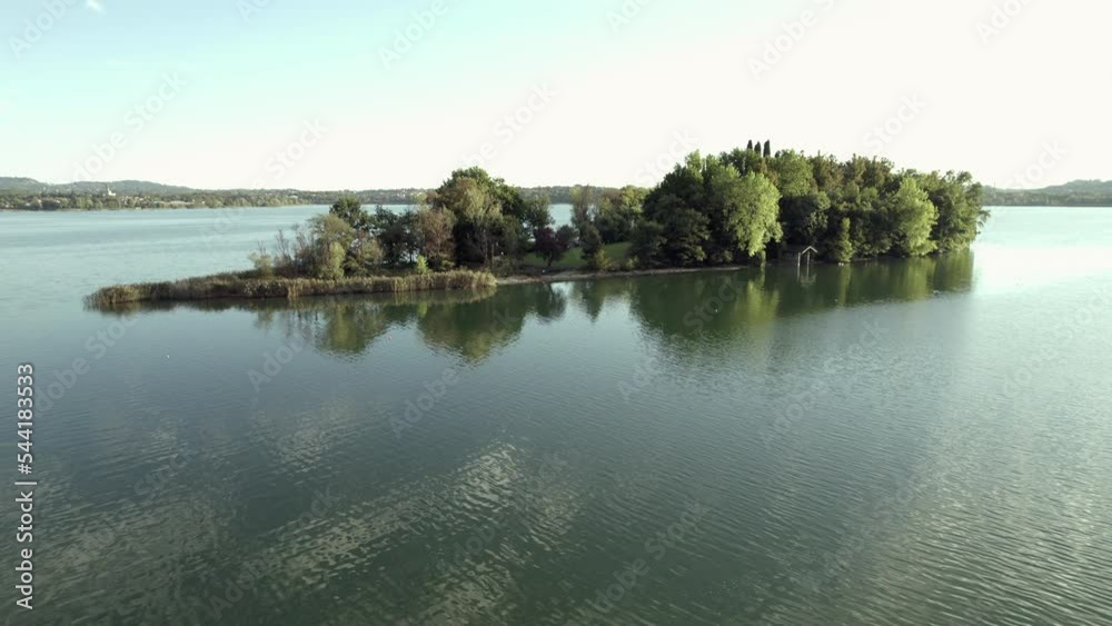 Drone Flying Over A tiny quiet island over the Lake in a summer day. Travel destination - Lake Pusiano, Lombardy, Italy Drone Flying Over A tiny quiet island over the Lake in a summer day. Travel destination - Lake Pusiano, Lombardy, Italy