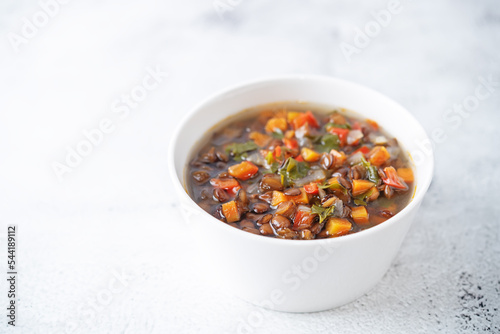 Green Lentil carrots red pepper vegan soup in a bowl