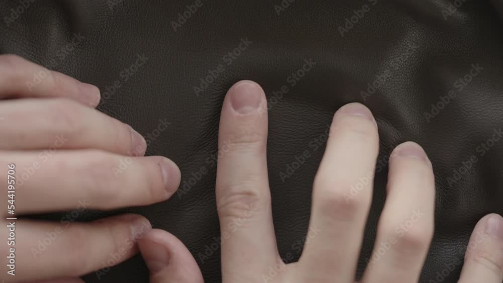 Top down shot of man hand inspecting soft gray leather Top down shot of man hand inspecting soft gray leather