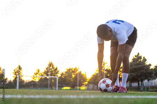 Football player placing the ball on the grass. Low angle of football player putting the ball on the grass in free kick