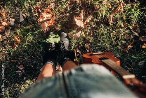 Conceptual image of legs in boots on the autumn leaves. Feet shoes walking in nature photo