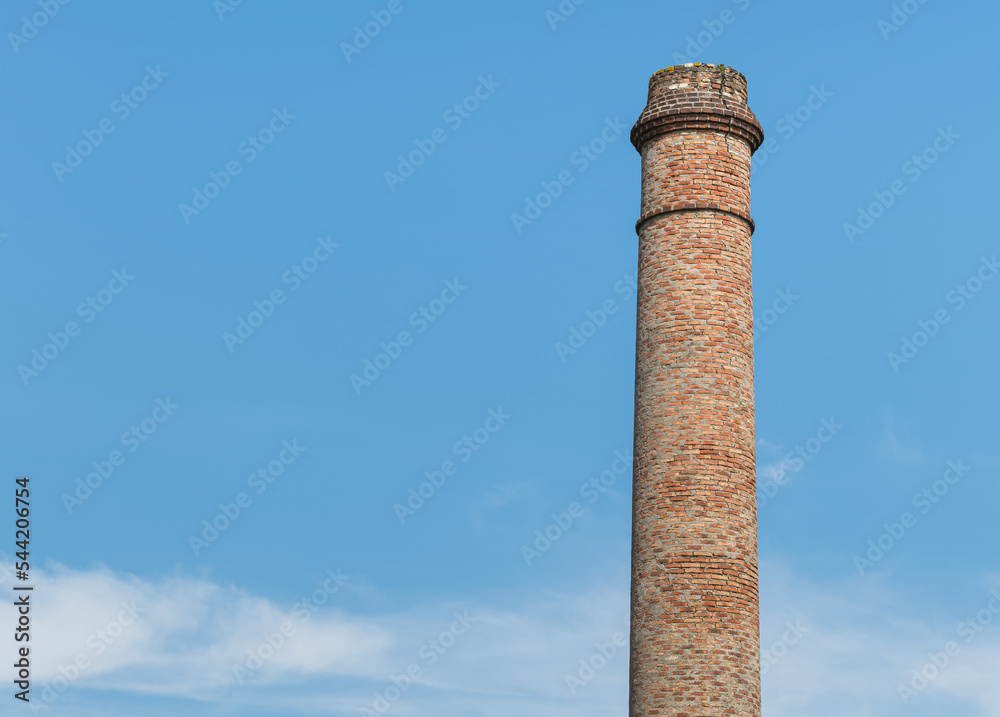 old industrial chimney over blue sky with clouds