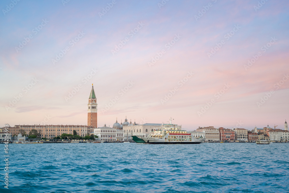 View of Venice Grand Canal and Santa Maria della Salute church in the evening and sunset. Piazza San Marco from river. Gondola and boats traditional. Carnival and mask. Italy holidays on winter.
