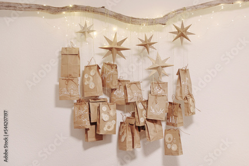 Handcrafted craft paper bags hang on the tree branch selfmade advent calendar