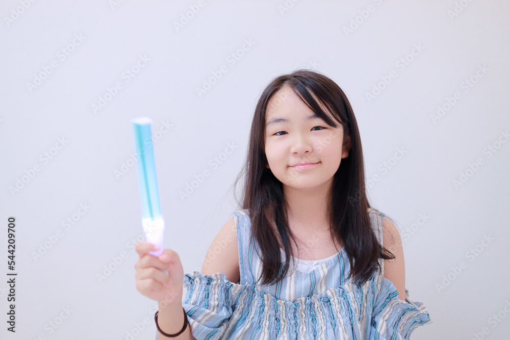 右手にペンライトを持った笑顔の少女 右手にペンライトを持った笑顔の少女