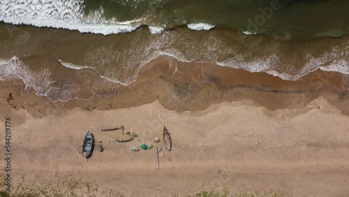 Overhead Shot of Waves Crashing on a Sea Beach with Some Fishing Boats photo