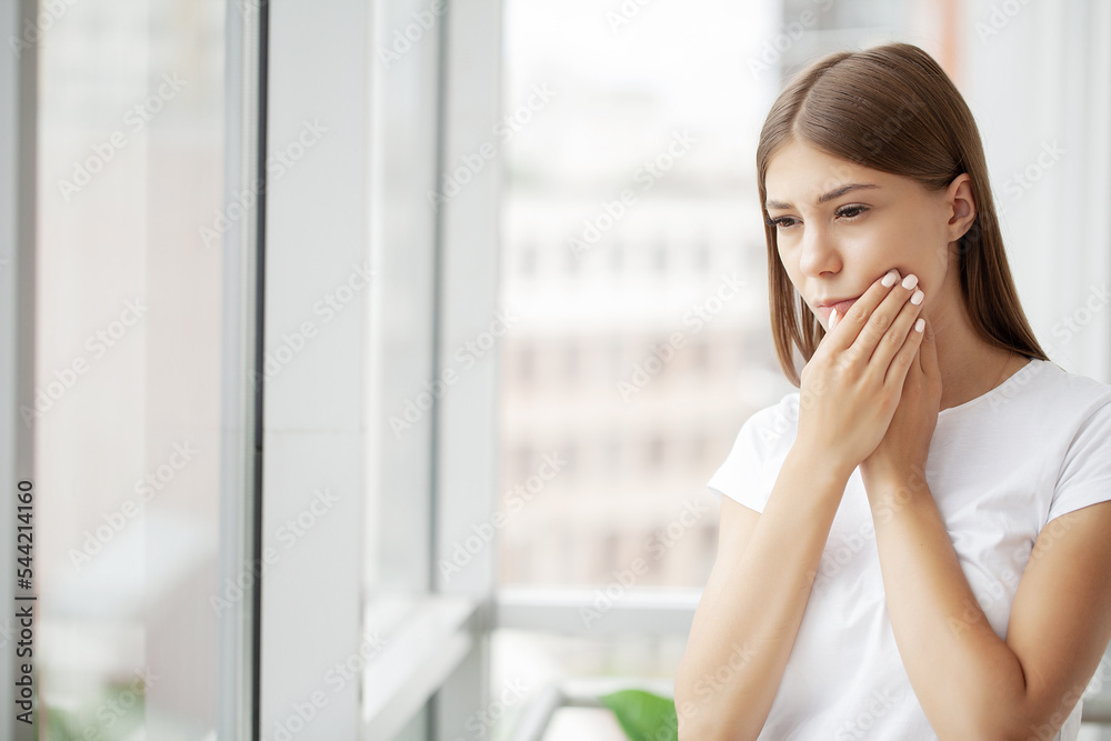 Young female business woman feels a toothache in her office Young female business woman feels a toothache in her office