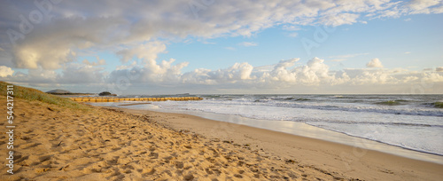 Φωτογραφία Early morning at Cotton Tree beach showing cloudy sky, surf waves rollig in, a popular sandy beach and the sand filled geotextile containers building a seawall or groyne to protect against erosion