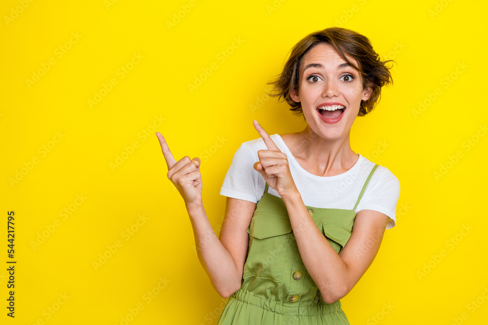 Photo of youngster bob brown hair stylish girl wear khaki overalls shocked fingers indicate good news mockup isolated on yellow color background Photo of youngster bob brown hair stylish girl wear khaki overalls shocked fingers indicate good news mockup isolated on yellow color background