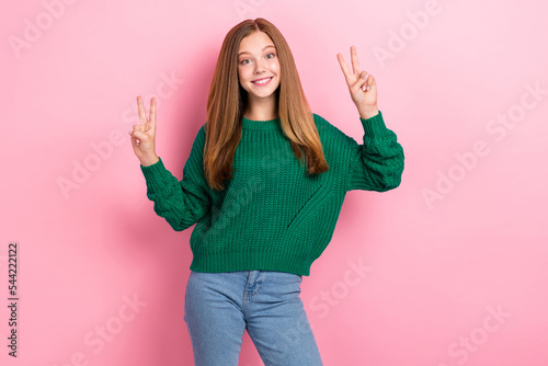 Photo of young popular blogger girl posing showing v-sign positive smiling wear stylish outfit green jumper denim isolated on pastel pink color background