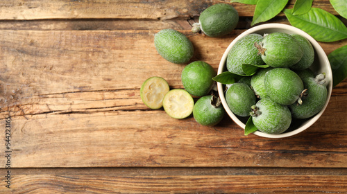 Flat lay composition with fresh green feijoa fruits on wooden table, space for text. Banner design