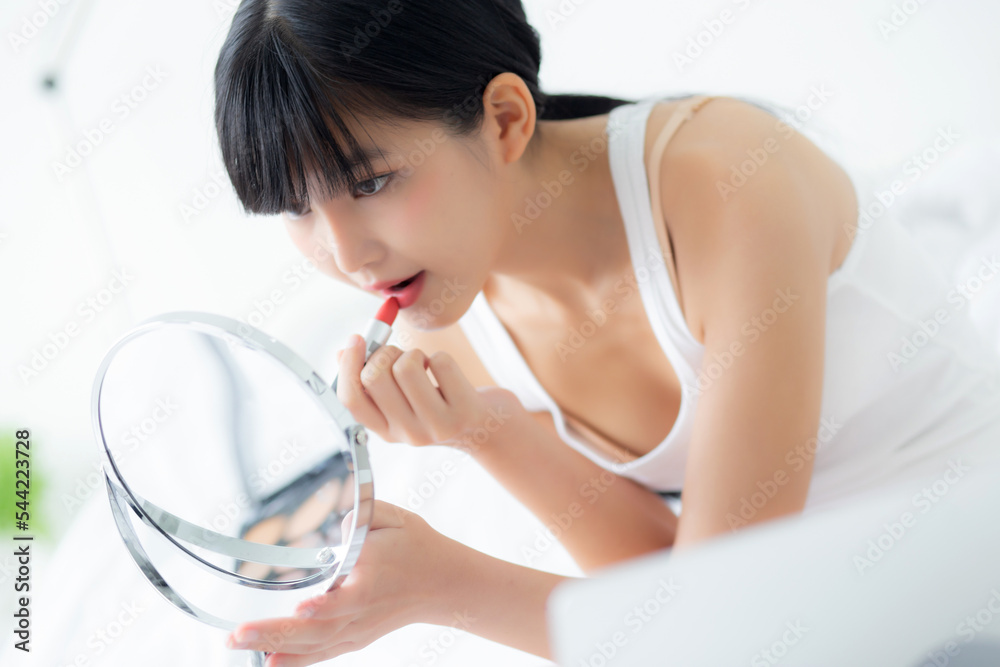 Beautiful young asian woman applying lipstick red on mouth, beauty girl looking facial at mirror for makeup cosmetic with lips elegance, make up with sexy of female, skin care and health concept. Beautiful young asian woman applying lipstick red on mouth, beauty girl looking facial at mirror for makeup cosmetic with lips elegance, make up with sexy of female, skin care and health concept.