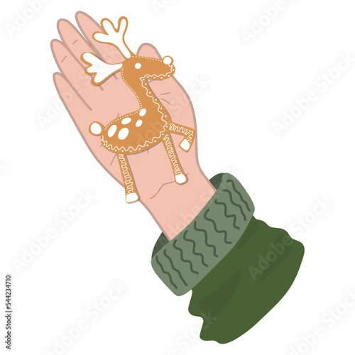 a hand with a Christmas gingerbread in the form of a deer