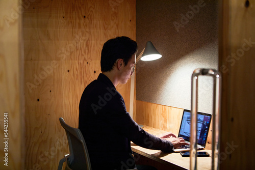 パーソナルブースで仕事する男性 photo
