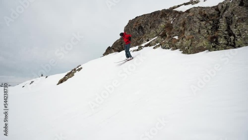 Freeskier jumps down the ledge in the winter photo