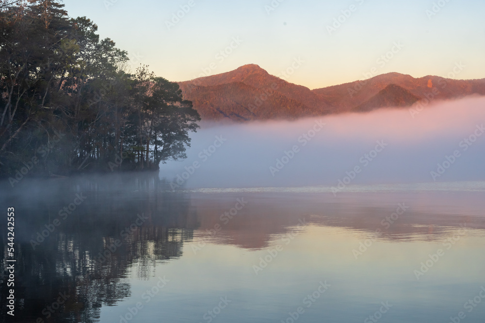 Obraz premium 湖面に朝靄の漂う早朝の湖。日本の北海道の屈斜路湖。