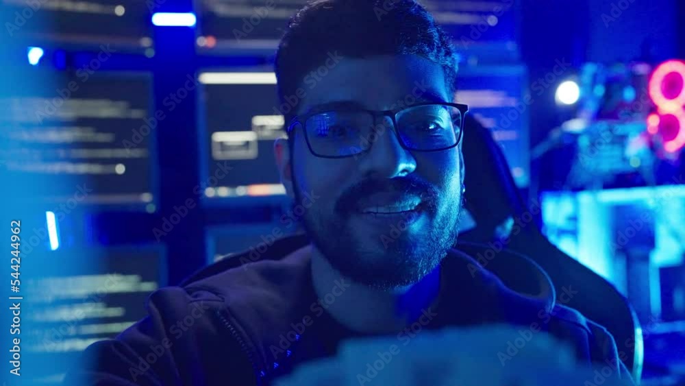 Male terrorists are hacking the security system. He looking to money and smile when success to hack data.