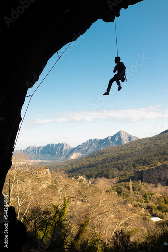the climber hangs on a rope in a cave