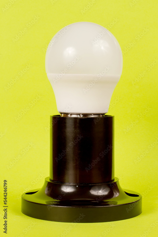 Energy-saving LED lamp in the socket on a green background. Close-up electric lamp. Energy-saving LED lamp in the socket on a green background. Close-up electric lamp.