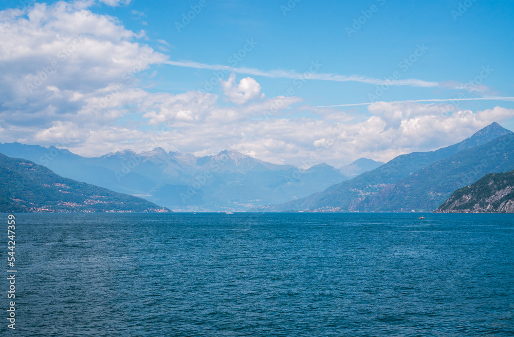 Beautiful panoramic view of Lake Como and the green Swiss Alps in the background on a sunny summer day. Lombardy, Italy.