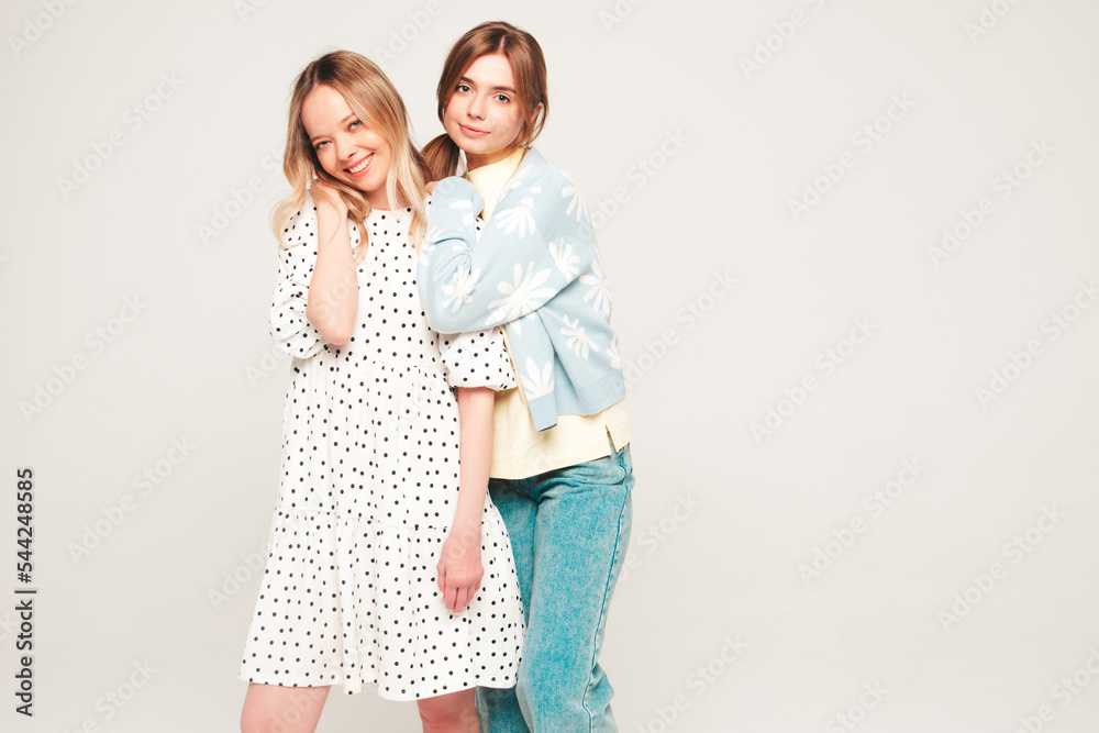 Two young beautiful smiling brunette hipster female in trendy summer clothes. Sexy carefree women posing near wall. Positive models having fun. Cheerful and happy Two young beautiful smiling brunette hipster female in trendy summer clothes. Sexy carefree women posing near wall. Positive models having fun. Cheerful and happy