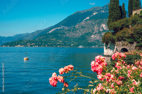 Beautiful view of Lake Como and Alpine mountains visible from the botanical garden of Villa Cipressi, Varenna, Italy. Italian landscape, on a sunny summer day.