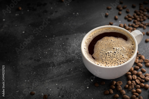Coffee background, top view with copy space. White cup of coffee, ground coffee, coffee beans on dark wooden background