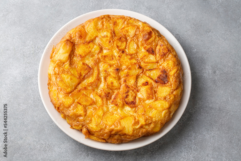 Spanish omelette with potatoes, typical spanish cuisine on gray concrete floor. Tortilla Espanola. Turkish name; Yumurtali patates Spanish omelette with potatoes, typical spanish cuisine on gray concrete floor. Tortilla Espanola. Turkish name; Yumurtali patates
