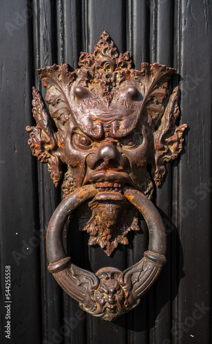 Fascinating door knocker in the shape of head on one of the entrance doors to the historic Villa Monastero, the villa of lords, Varenna, Province of Lecco, Italy.