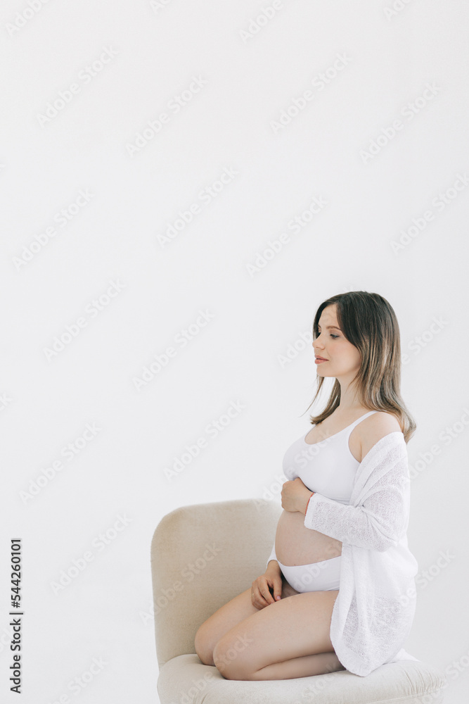 Young pregnant woman on a light background. The concept of conscious parenting, happy motherhood and easy pregnancy. Mental health and harmony. Young pregnant woman on a light background. The concept of conscious parenting, happy motherhood and easy pregnancy. Mental health and harmony.